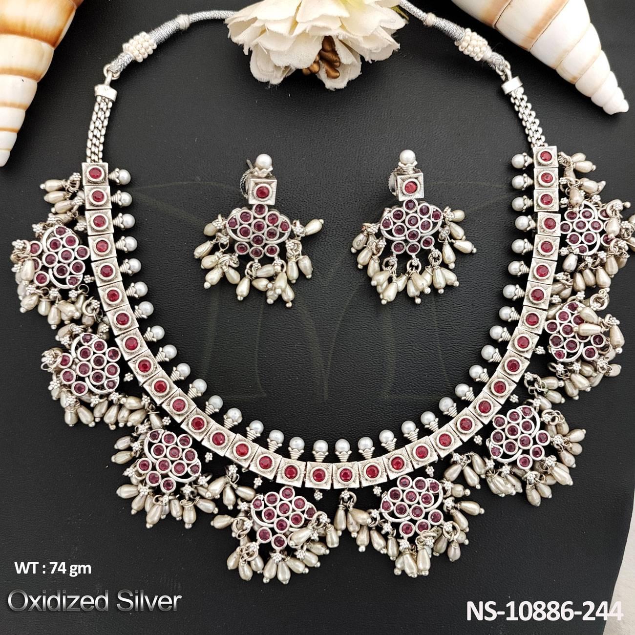 This exquisite short necklace set is perfect for the Navratra festival. Made with oxidized silver polish and featuring a fancy design, it adds a touch of elegance to any outfit.