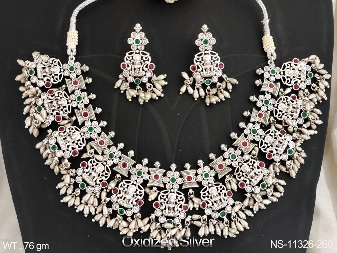 This stunning Temple Jewellery Short Necklace Set features an intricate Laxmi design with oxidised silver polish, giving it a unique and elegant look.